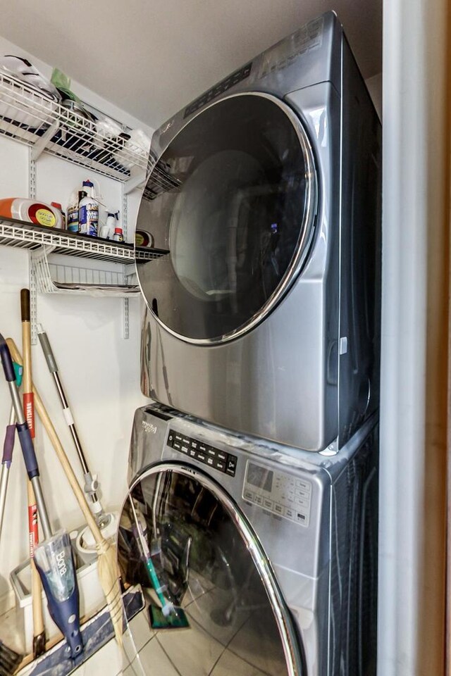 washroom with tile patterned flooring, laundry area, and stacked washer and dryer