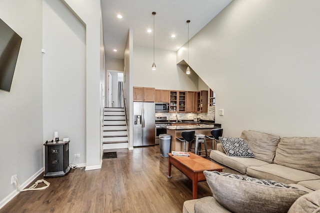1622 W Ontario St Unit 1E, Chicago, IL 60622 - living room featuring dark wood finished floors, stairs, a towering ceiling, baseboards, and recessed lighting