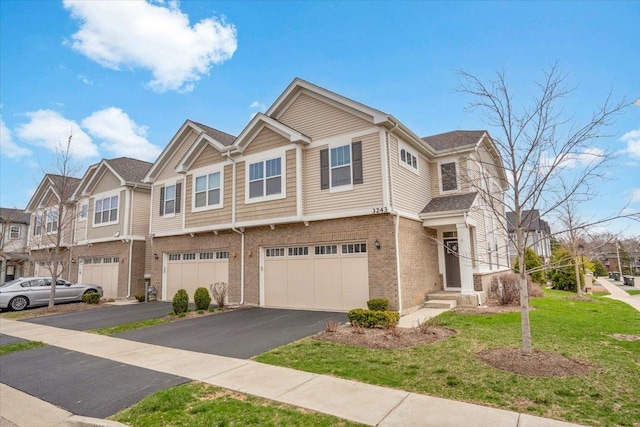 view of property featuring brick siding, aphalt driveway, a residential view, a front yard, and an attached garage
