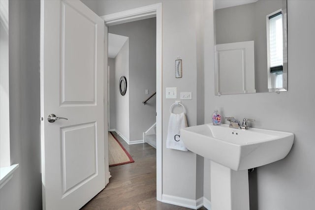 bathroom with a sink, wood finished floors, and baseboards