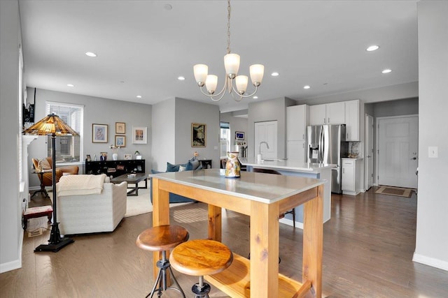 dining room with recessed lighting, an inviting chandelier, baseboards, and dark wood finished floors