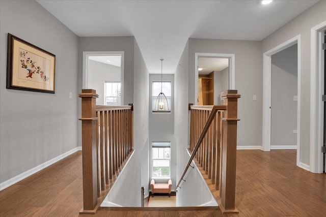 stairs with wood finished floors, plenty of natural light, recessed lighting, and baseboards