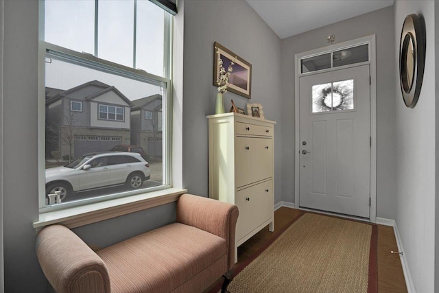 foyer featuring baseboards and wood finished floors