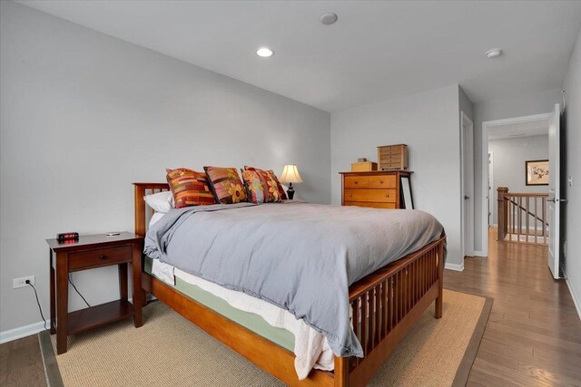 bedroom with recessed lighting, wood finished floors, and baseboards