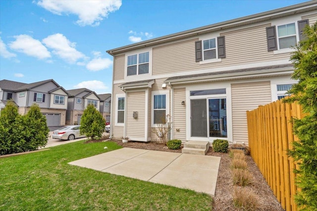 back of house with fence, entry steps, a residential view, and a lawn