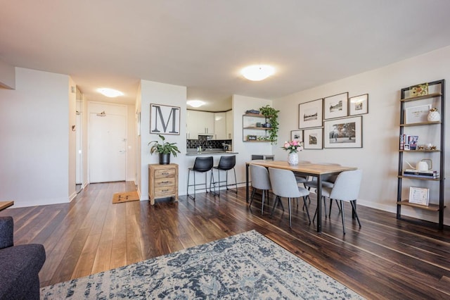 dining area featuring baseboards and dark wood-style flooring