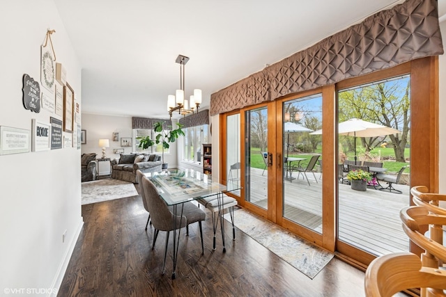 dining area with baseboards, a chandelier, and dark wood-type flooring