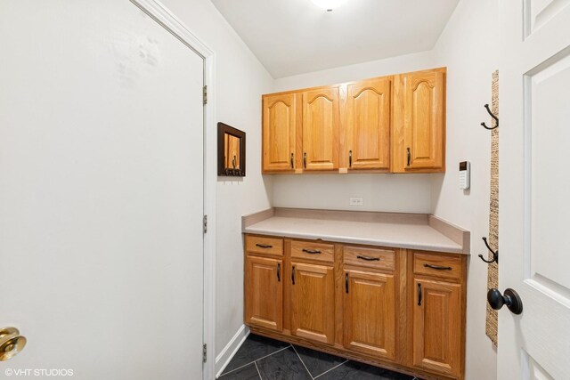 kitchen with dark tile patterned flooring and light countertops