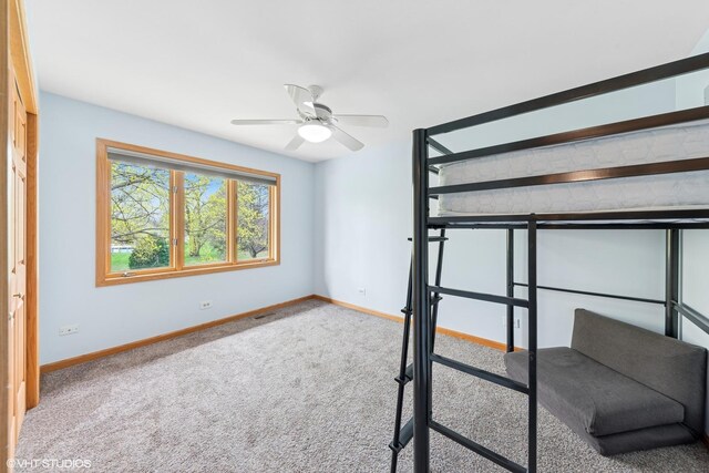 unfurnished bedroom featuring baseboards, a ceiling fan, carpet flooring, and visible vents