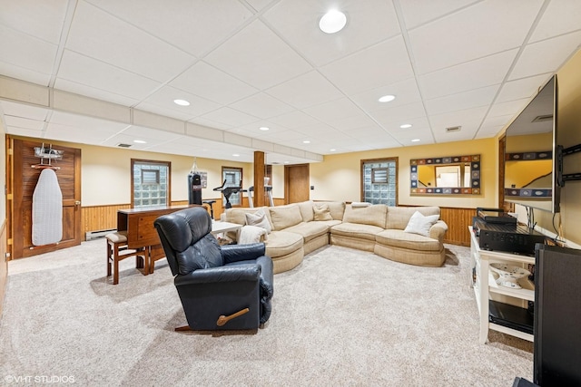 living room with baseboard heating, a wainscoted wall, carpet flooring, and a paneled ceiling