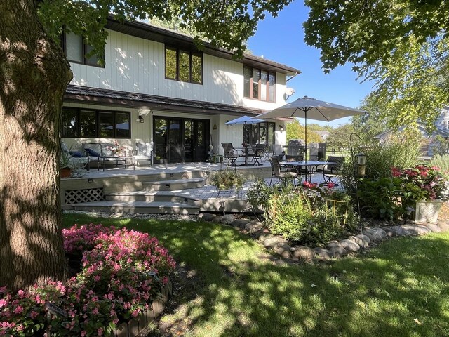 rear view of property with a lawn and a deck