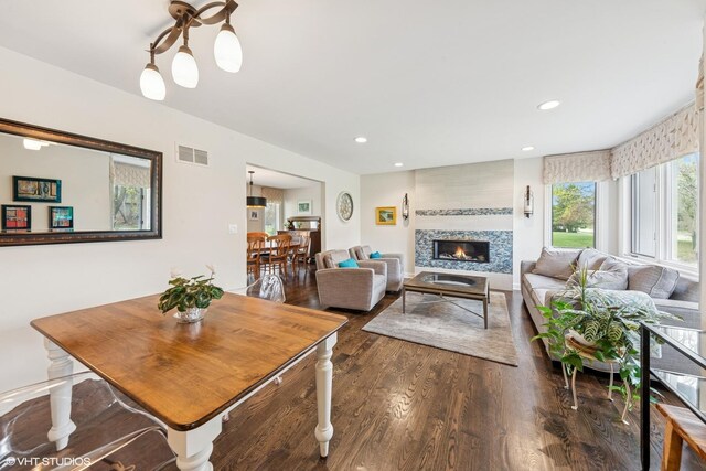 dining room with wood finished floors, visible vents, a fireplace, and recessed lighting