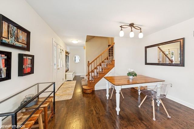 dining room featuring baseboards, wood finished floors, and stairway