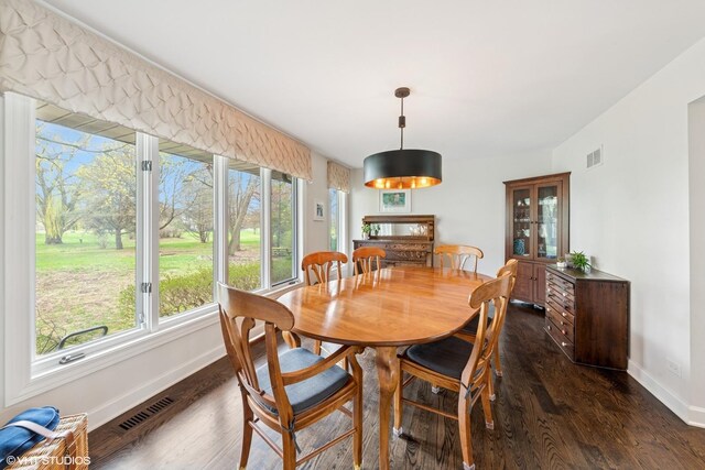 dining room with dark wood finished floors, baseboards, and visible vents