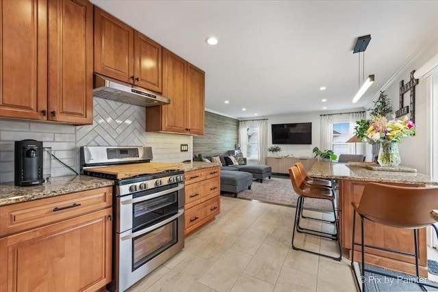 1682 Brompton Ln, Crystal Lake, IL 60014 - kitchen with a breakfast bar, under cabinet range hood, tasteful backsplash, light stone counters, and double oven range