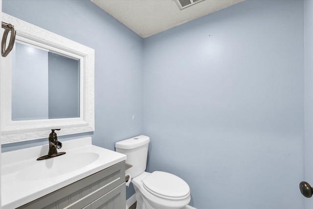 half bath featuring toilet, vanity, and baseboards