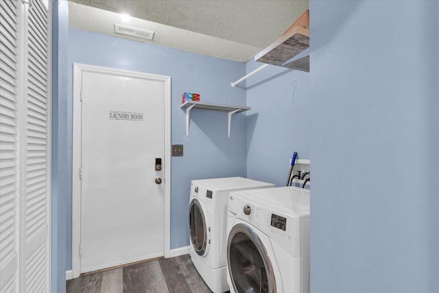 laundry room featuring washer and clothes dryer, dark wood finished floors, a textured ceiling, and baseboards