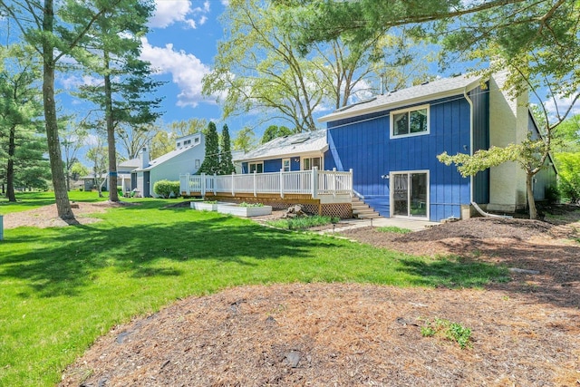 back of property featuring a deck, a yard, and a chimney