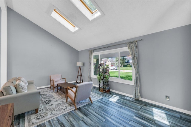 living room featuring a skylight, vaulted ceiling, wood finished floors, and baseboards