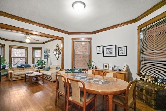 dining area featuring a ceiling fan, crown molding, and wood finished floors