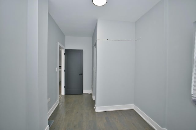 corridor with baseboards and dark wood-type flooring