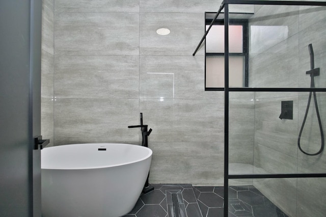 bathroom featuring tile patterned floors, a freestanding tub, and tiled shower