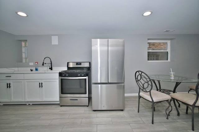 kitchen featuring white cabinets, appliances with stainless steel finishes, recessed lighting, and a sink