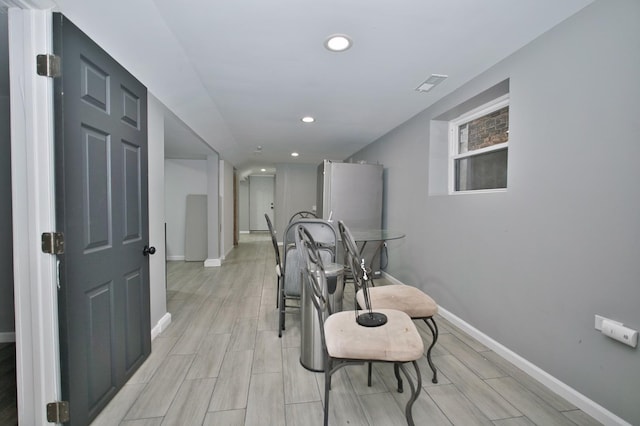 corridor with wood tiled floor, baseboards, visible vents, and recessed lighting