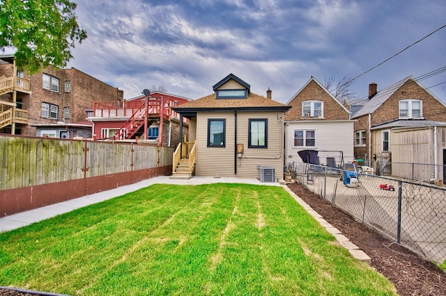 back of house with a fenced backyard, a yard, and cooling unit