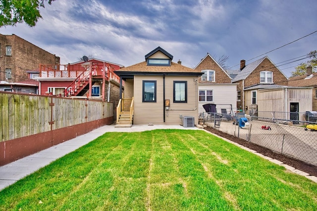 rear view of property with a lawn, a fenced backyard, and cooling unit