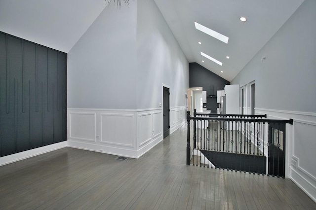 bonus room with high vaulted ceiling, a decorative wall, wood finished floors, a skylight, and visible vents