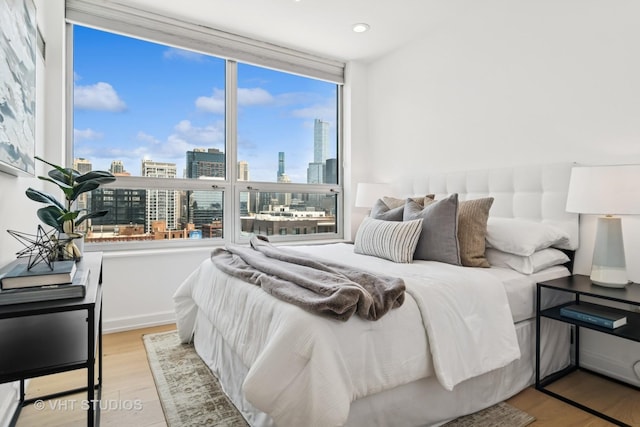 421 W Huron St Unit 1504, Chicago, IL 60654 - bedroom with a view of skyline, wood finished floors, and recessed lighting