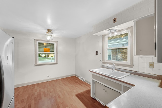 7616 S Lorel Ave, Burbank, IL 60459 - kitchen with refrigerator, a sink, light wood-type flooring, backsplash, and visible vents