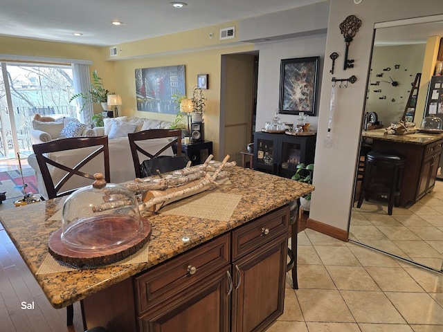 5201 Carriageway Dr Unit 315, Rolling Meadows, IL 60008 - kitchen with a center island, light stone countertops, a kitchen bar, and visible vents