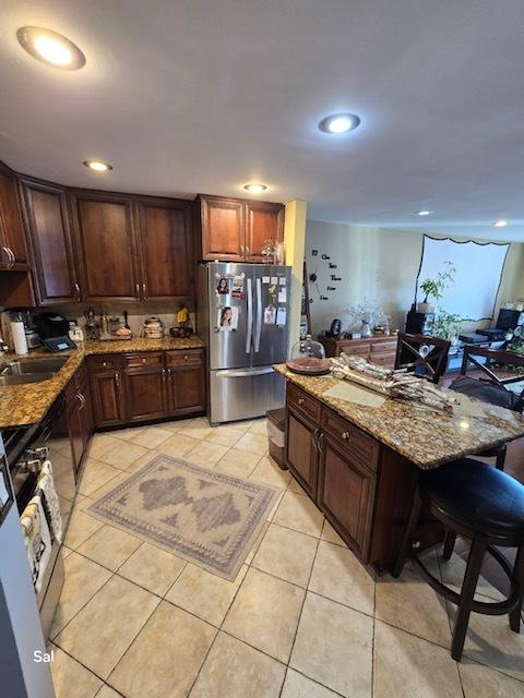 5201 Carriageway Dr Unit 315, Rolling Meadows, IL 60008 - kitchen with a sink, gas stove, freestanding refrigerator, stone counters, and light tile patterned flooring