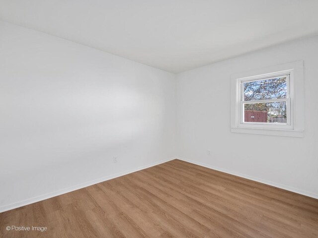 empty room featuring light wood-type flooring and baseboards