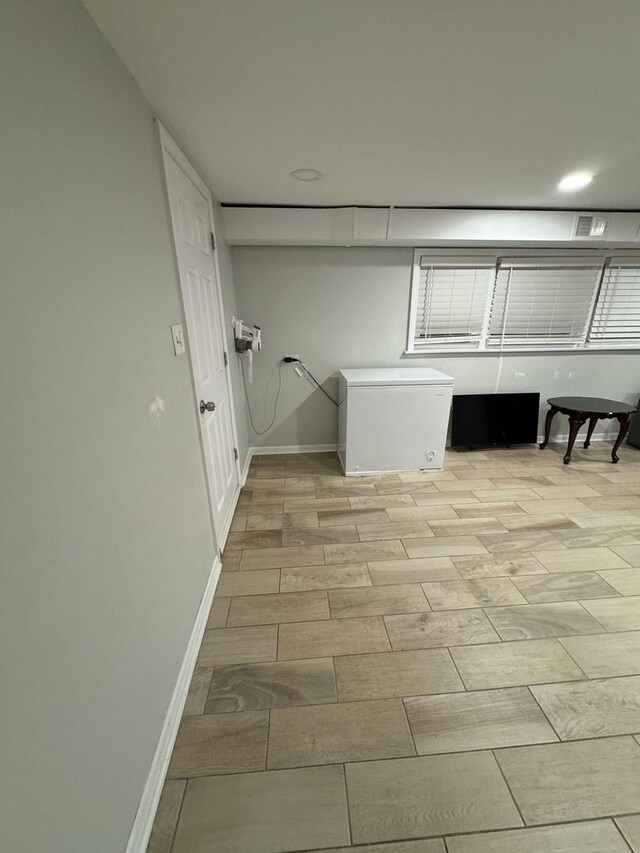 laundry area with wood finish floors and baseboards