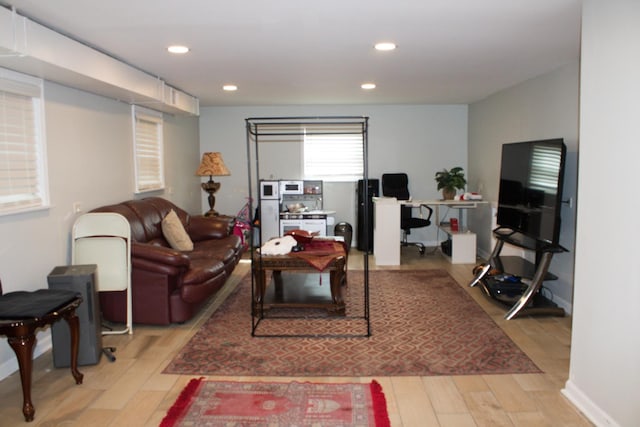 living area with light wood-style flooring, baseboards, and recessed lighting