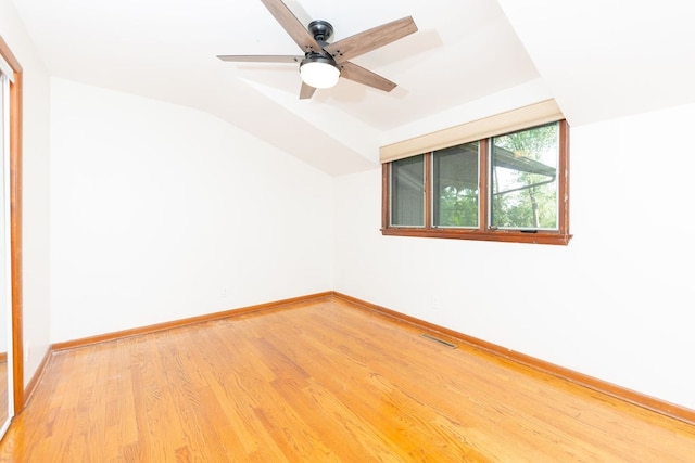 spare room with light wood-style flooring, lofted ceiling, baseboards, and ceiling fan