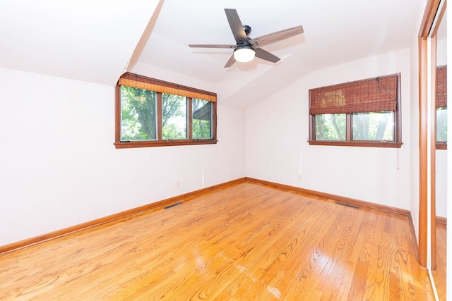 interior space with lofted ceiling, a healthy amount of sunlight, visible vents, and light wood-style flooring