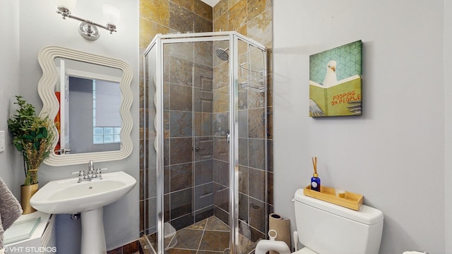 bathroom featuring toilet and a shower stall