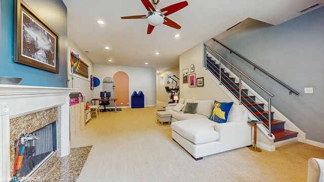 carpeted living room featuring a high end fireplace, stairway, a ceiling fan, and recessed lighting