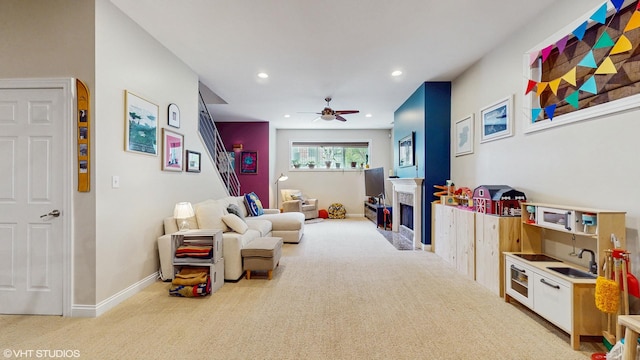 interior space featuring a ceiling fan, baseboards, a fireplace with flush hearth, and recessed lighting