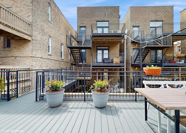 back of property with brick siding and a balcony