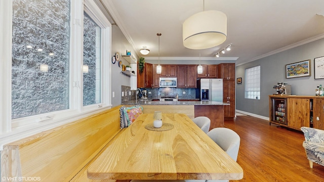 dining room with crown molding, baseboards, and dark wood-style floors
