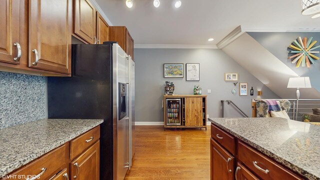 kitchen with light stone countertops, baseboards, stainless steel fridge with ice dispenser, light wood finished floors, and ornamental molding