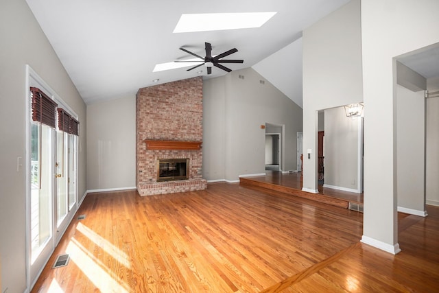 4240 Kingshill Cir, Naperville, IL 60564 - unfurnished living room featuring a skylight, high vaulted ceiling, wood finished floors, and a fireplace