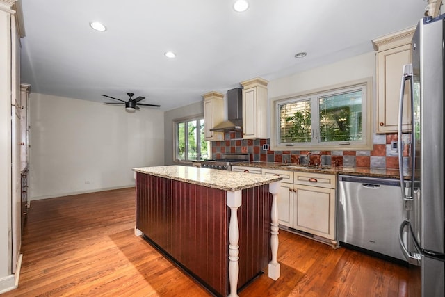 4240 Kingshill Cir, Naperville, IL 60564 - kitchen with stainless steel appliances, cream cabinets, wall chimney range hood, a ceiling fan, and tasteful backsplash