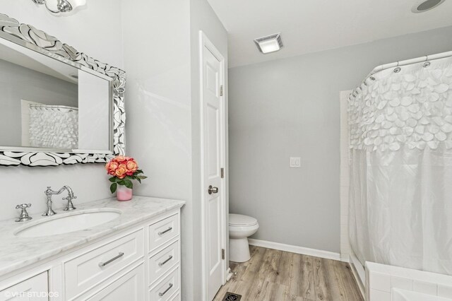 214 Woodstone Dr, Buffalo Grove, IL 60089 - full bathroom featuring vanity, toilet, baseboards, wood finished floors, and visible vents