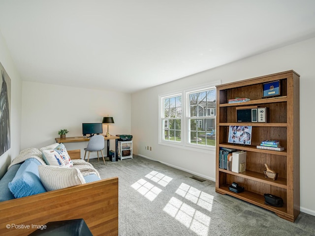 living area featuring baseboards, visible vents, and carpet